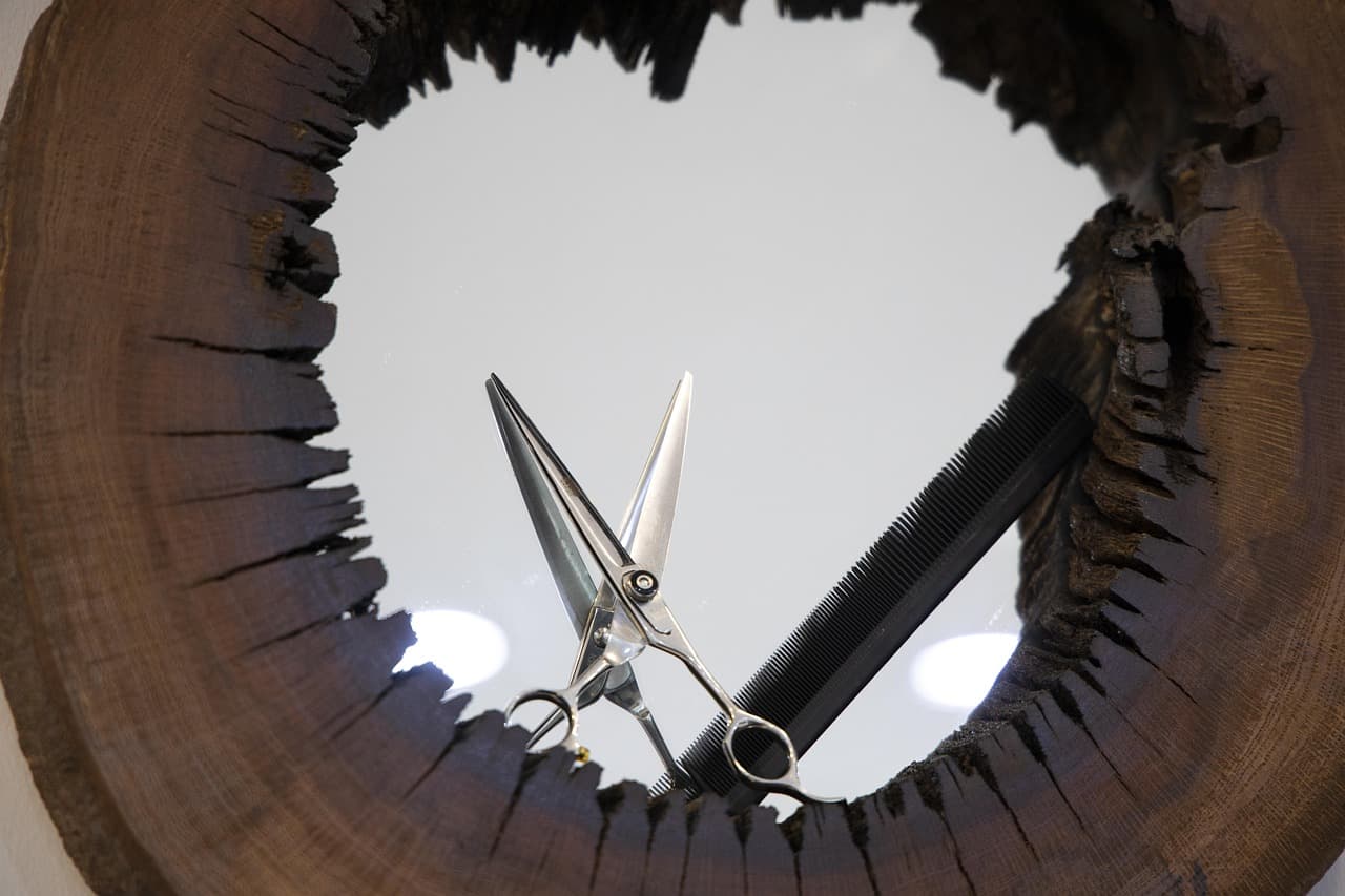 Barber scissors and comb reflected in a round mirror